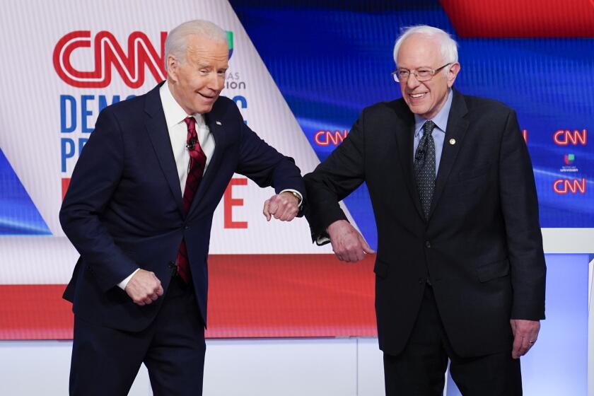 Former Vice President Joe Biden, left, and Sen. Bernie Sanders, I-Vt., right, greet each other before they participate in a Democratic presidential primary debate at CNN Studios in Washington, Sunday, March 15, 2020. (AP Photo/Evan Vucci)