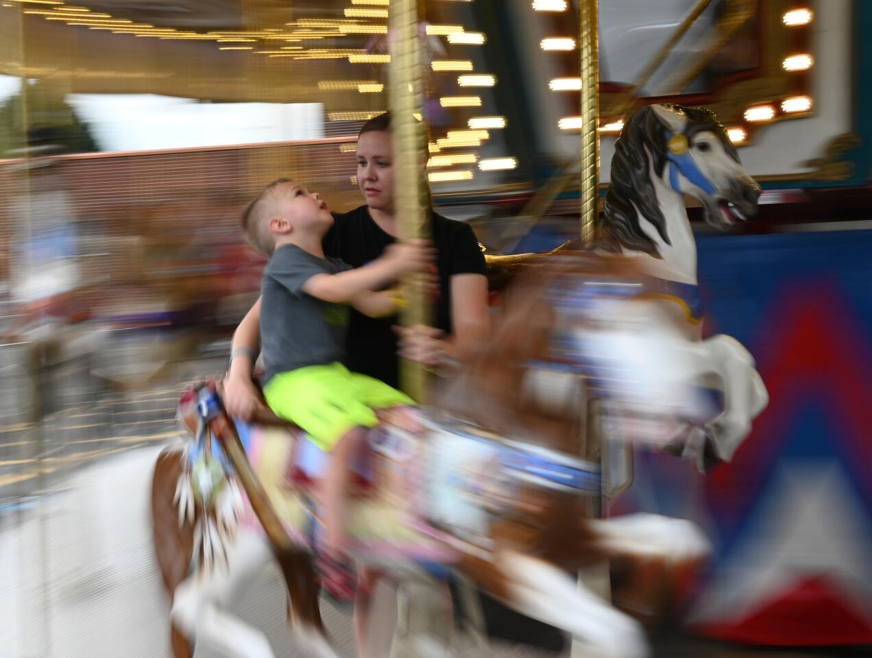 Emily Cugle of Westminster and her e-year-old son Brendan go for a spin on the carousel during the carnival at Reese & Community Volunteer Fire Company on Tuesday, July 16.