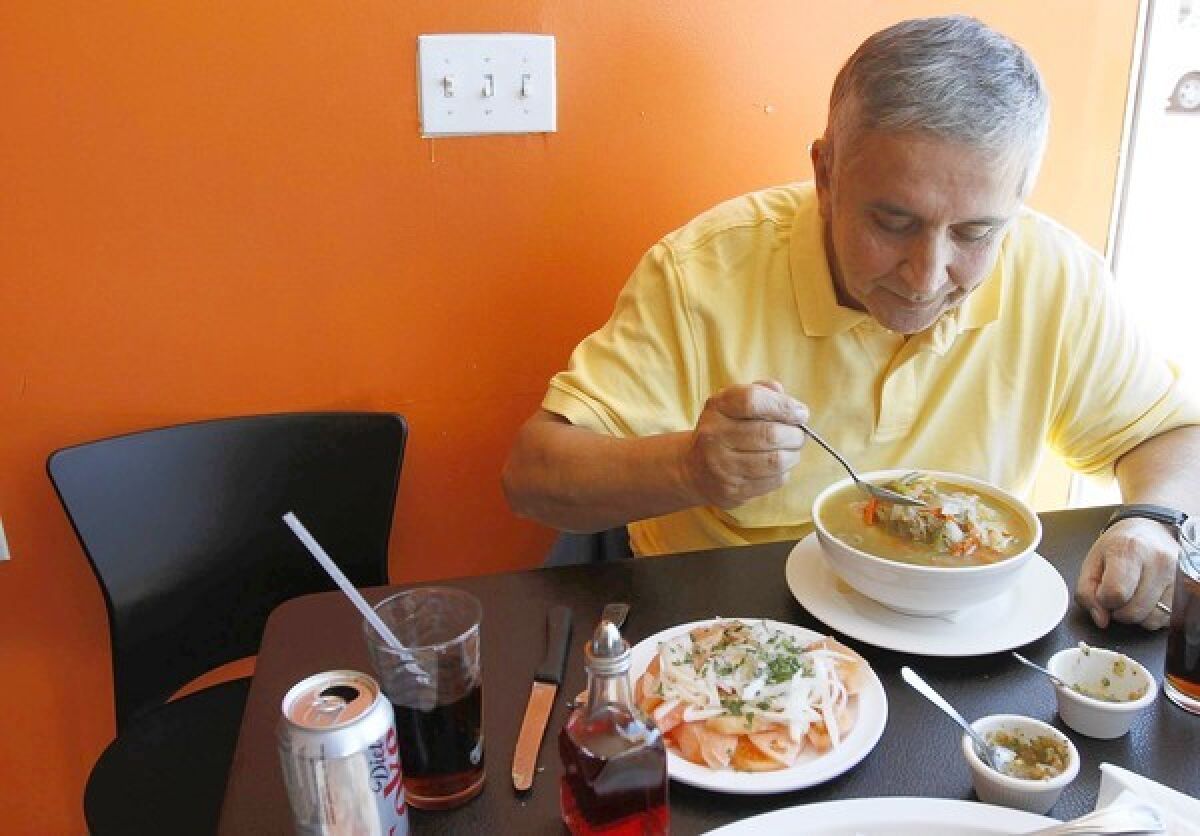 Francisco Aldoney customizes his bowl of cazuela de vacuno (a traditional Chilean beaf stew) at Chilenazo in Canoga Park.