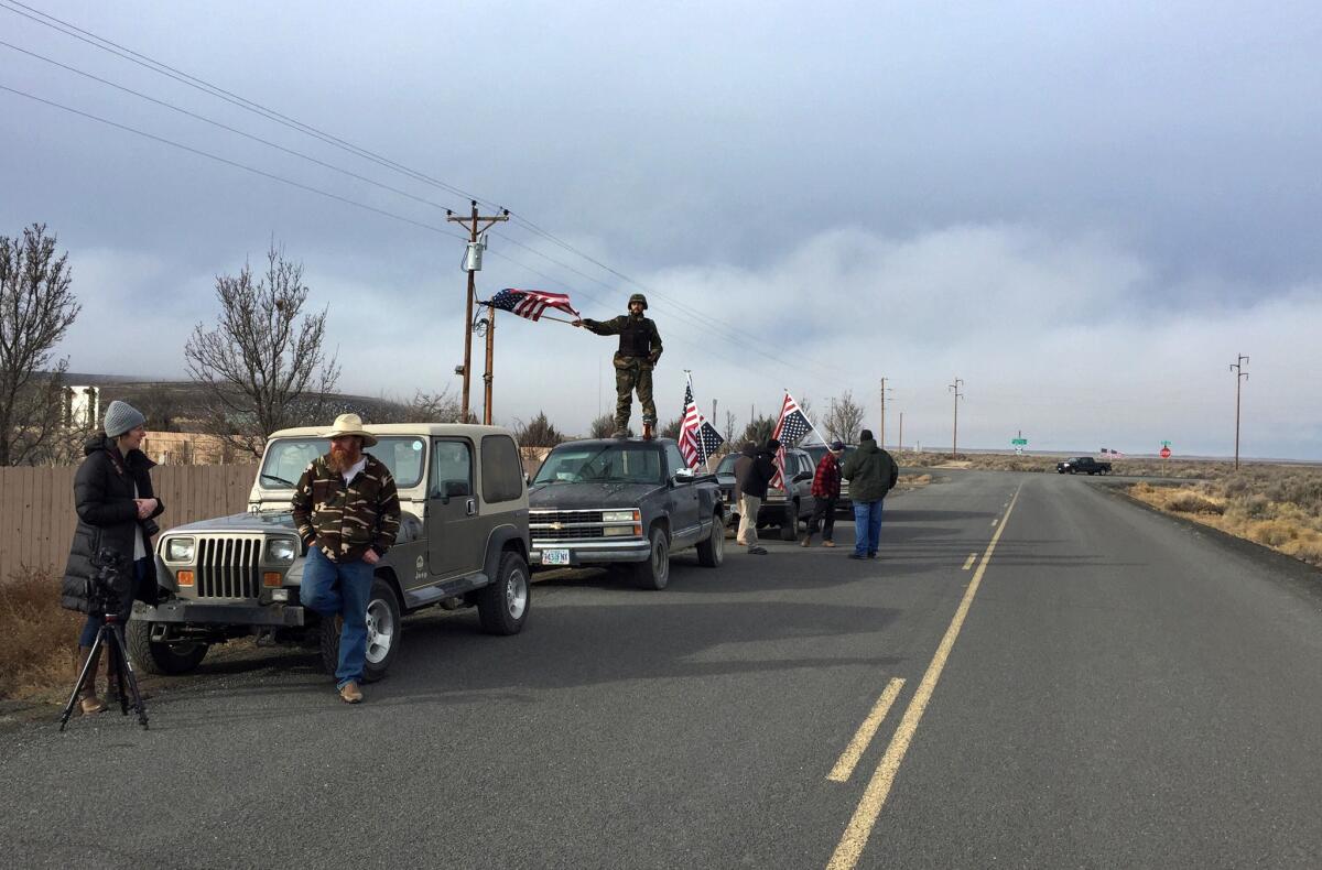 People wave American flags near the Malheur National Wildlife Refuge in Oregon as negotiations were underway that led to the surrender of the last four occupiers.