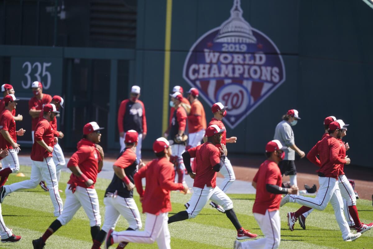 Washington Nationals warm up during a baseball workout at Nationals Park, Monday, April 5, 2021, in Washington. The Nationals are scheduled to play the Braves on Tuesday. (AP Photo/Alex Brandon)