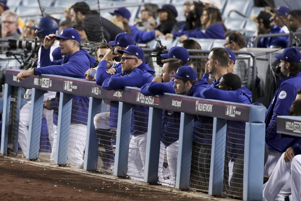 Dodgers players watch the game unhappily from the dugout.