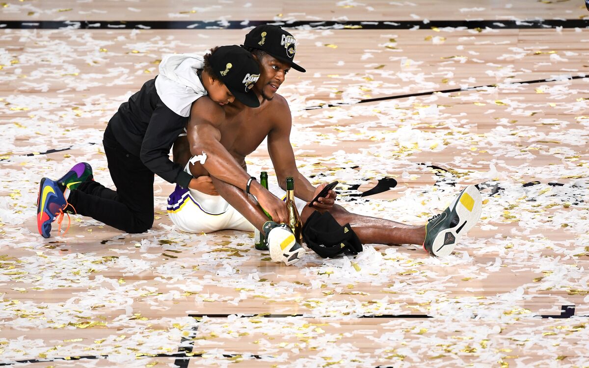 Guard Rajon Rondo and his son, Rajon Jr., celebrate on the court after the Lakers won the title on Sunday.