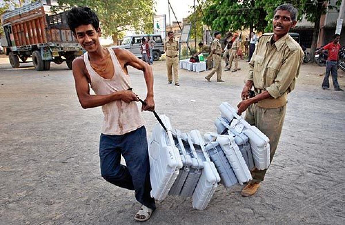 A security worker helps carry voting machines that will be transported to a polling booth in Gaya, in the eastern Indian state of Bihar, on election eve. Indian voters will cast ballots Thursday in five-phase national elections that will span a month.