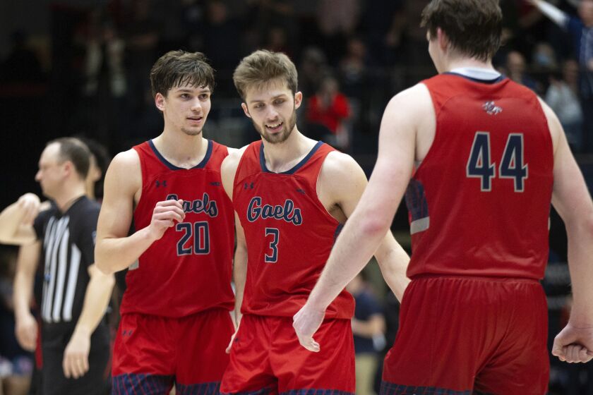Saint Mary's guards Aidan Mahaney (20), Augustas Marciulionis (3) and Alex Ducas (44) celebrate during the closing seconds of the overtime period of an NCAA college basketball game against Gonzaga, Saturday, Feb. 4, 2023, in Moraga, Calif. Saint Mary's won 78-70. (AP Photo/D. Ross Cameron)