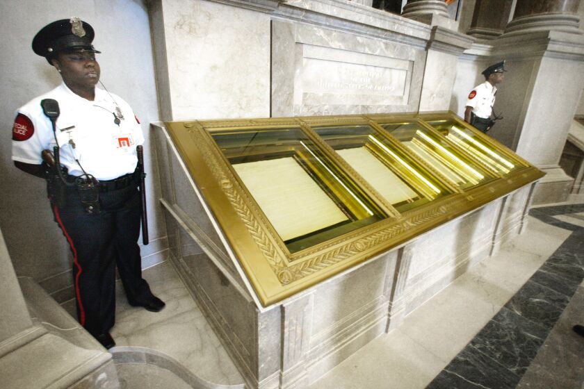 FILE - In this Sept. 16, 2003 file photo, guards stand next to the U.S. Constitution in the Rotunda of the National Archives in Washington. If there’s one thing Republicans and Democrats can agree on when it comes to guns, it’s their proclaimed respect for the Second Amendment. Lawyers, scholars, judges, politicians and ordinary Americans have been puzzling over that question for much of two centuries. (AP Photo/Ron Edmonds, File)