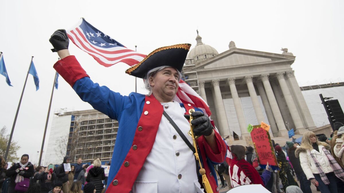 A man in a Revolutionary War outfit joins teachers in a rally at the state Capitol in Oklahoma City on Monday.