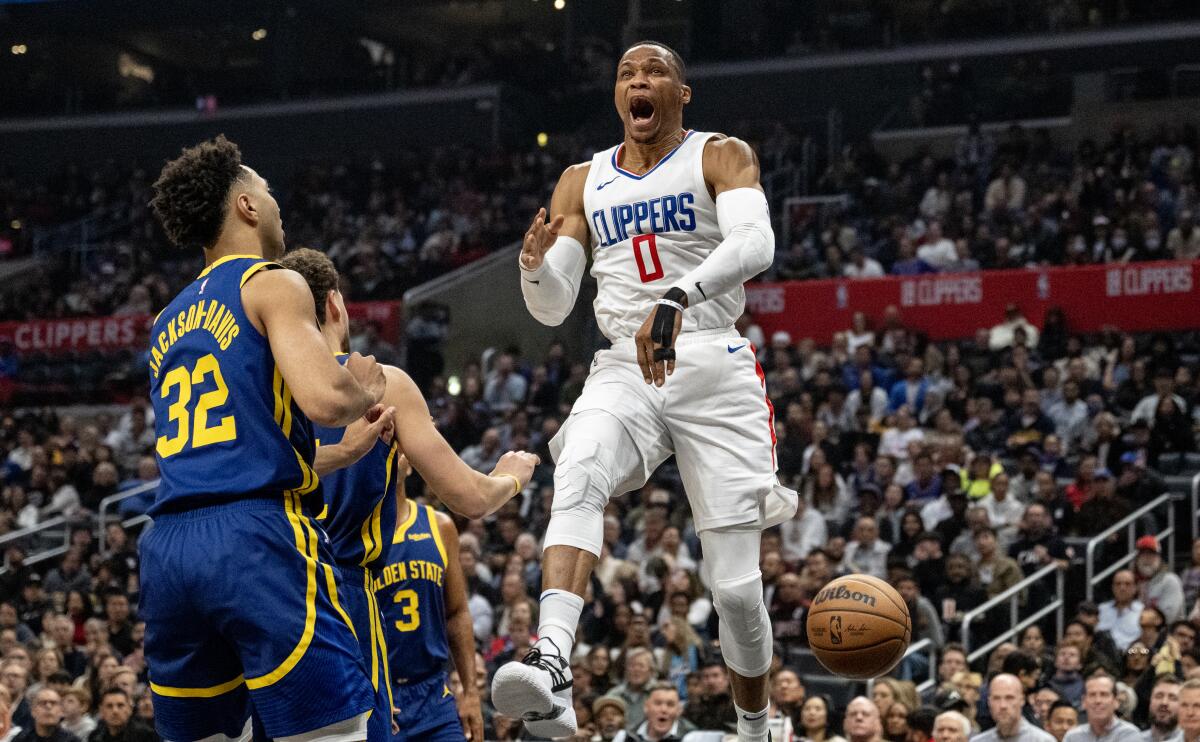 Clippers guard Russell Westbrook yells after dunking in front of Golden State Warriors forward Trayce Jackson-Davis.