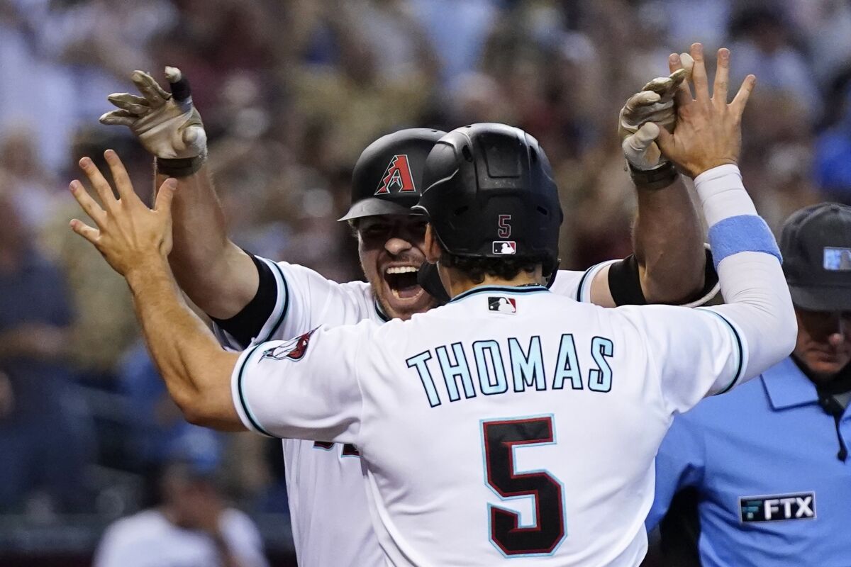 Arizona Diamondbacks' Buddy Lewis Kennedy, left, celebrates his grand slam against the Minnesota Twins with Diamondbacks' Alek Thomas (5) during the sixth inning of a baseball game, Sunday, June 19, 2022, in Phoenix. For Kennedy, it was his first MLB home run. (AP Photo/Ross D. Franklin)