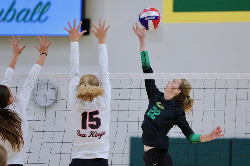 Mira Costa's Audrey Flanagan lofts the ball over a pair of Palos Verdes blockers.