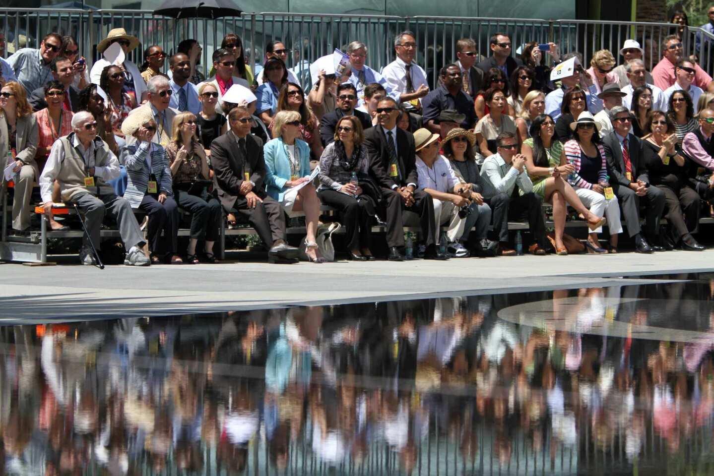 The crowd is reflected in the wading pool during the official opening of two blocks of the new Grand Park.