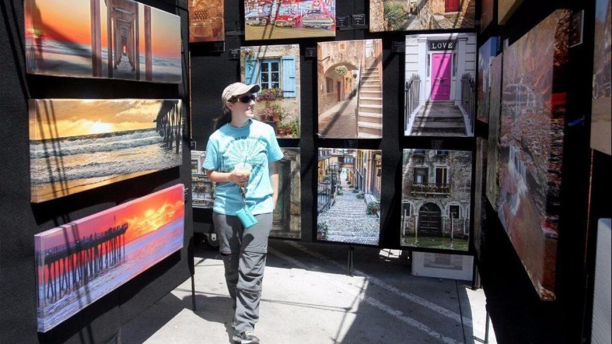 Allison Elvove of Burbank looks over supersized prints on canvas at the Fab Photography booth at the Downtown Burbank Arts Festival on Saturday, April 16, 2016.
