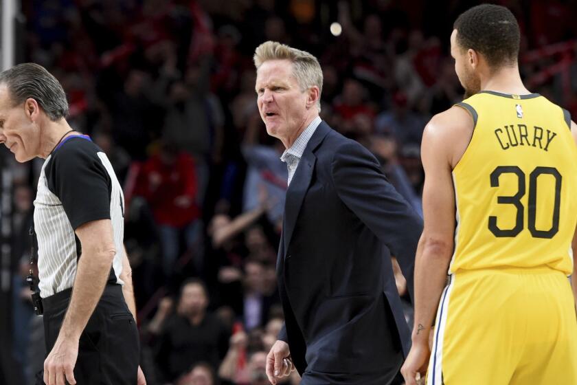 Golden State Warriors coach Steve Kerr, center, yells at referee Ken Mauer, left, after being called for a technical foul, while guard Stephen Curry, right, watches during the second half of an NBA basketball game against the Portland Trail Blazers in Portland, Ore., Wednesday, Feb. 13, 2019. The Blazers won 129-107. (AP Photo/Steve Dykes)
