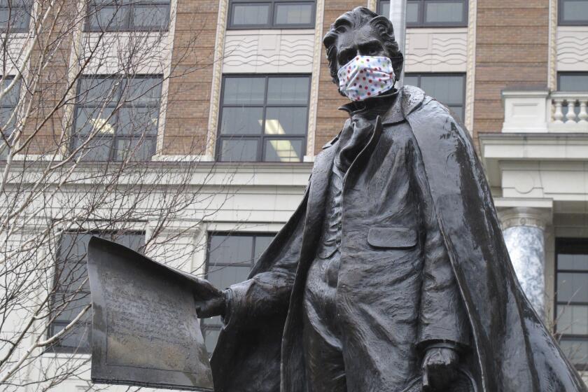 A statue of William Seward near the Alaska Capitol is shown outfitted with a mask on Friday, April 24, 2020, in Juneau, Alaska. On Friday, the state began allowing restaurants to resume dine-in service and retail shops and other businesses to reopen, all with limitations, under an initial phase of a plan to restart parts of the economy affected by coronavirus concerns. (AP Photo/Becky Bohrer)