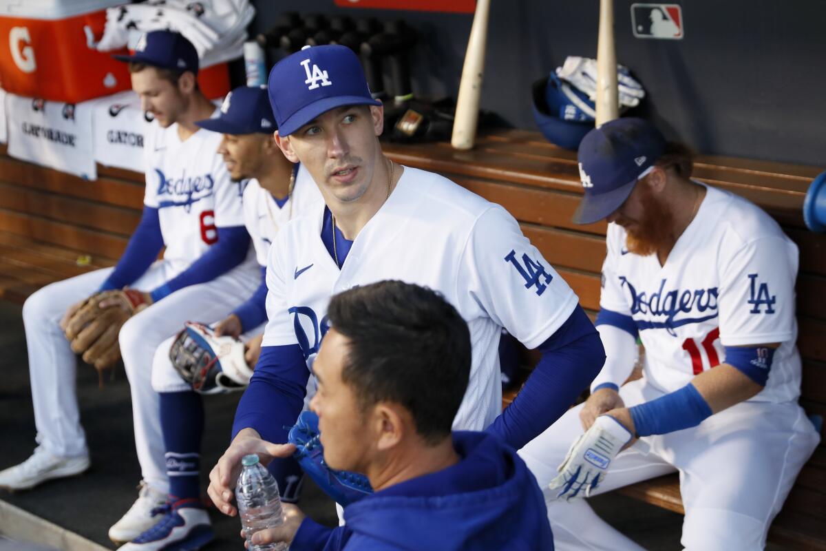 Dodgers pitcher Walker Buehler stands in the dugout in the first inning.