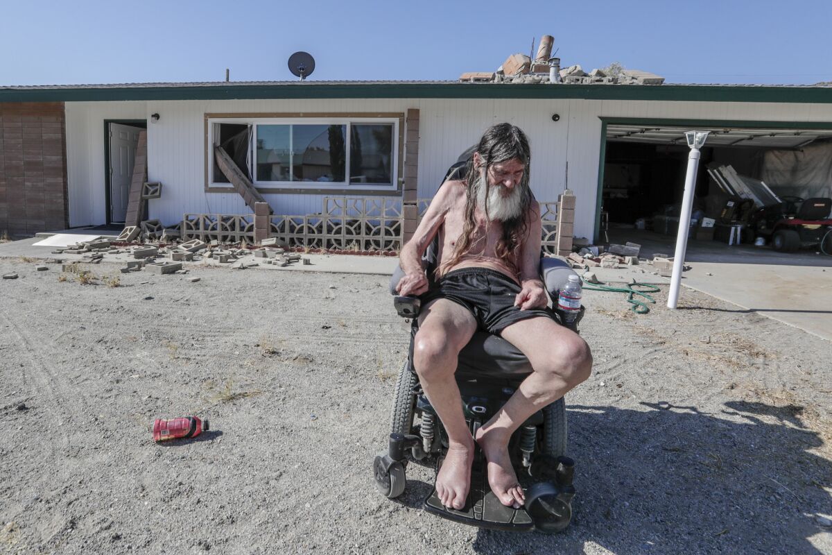 Charles Ware, 68, in his Trona front yard the morning after a 7.1 magnitude earthquake severely damaged his home. Ware said he invested all he had into this house two years ago, doesn’t have earthquake insurance and is afraid he may not be able to rebuild. He was on the phone with his brother in San Diego when the quake hit. “I got to ride it out with my brother,” he said. (Robert Gauthier / Los Angeles Times)