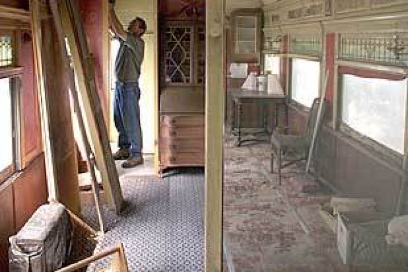 Robert Smaus removes part of a wall in the once-grand Southern Pacific passenger car on his mountain property. One section has been gutted.