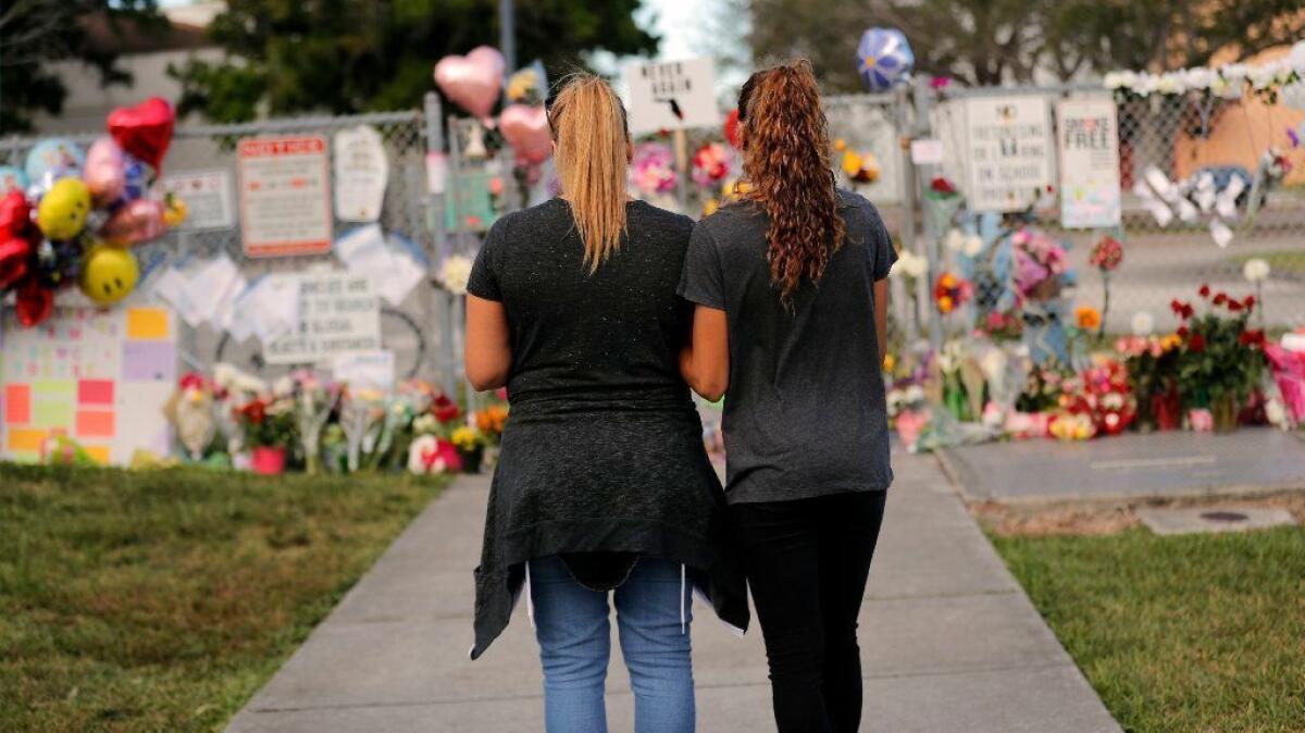 A mother and her daughter visit a makeshift memorial to shooting victims at the Marjory Stoneman Douglas High School in Parkland, Fla., on Feb. 19, 2018.