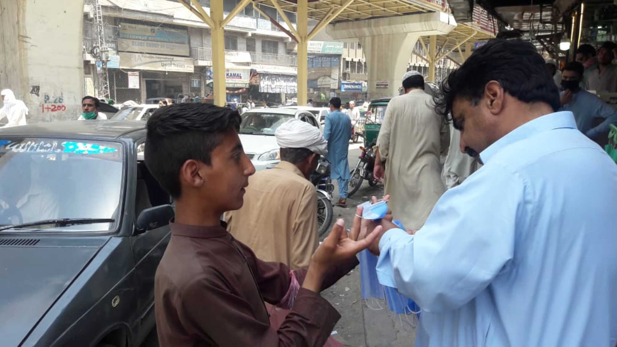 Junaid, de 13 años, a la izquierda, vende mascarillas en el distrito de Khyber Bazaar de Peshawar, Pakistán.