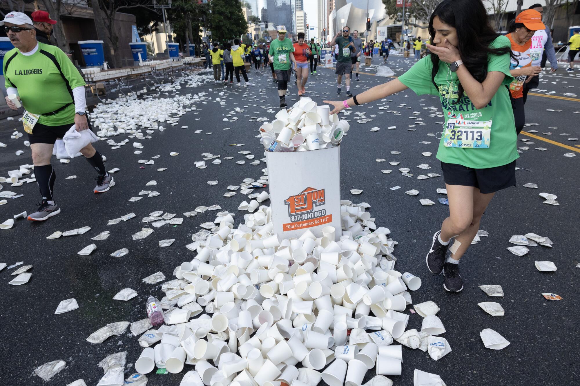 塑料杯从垃圾桶里溢出，洒满了街道。