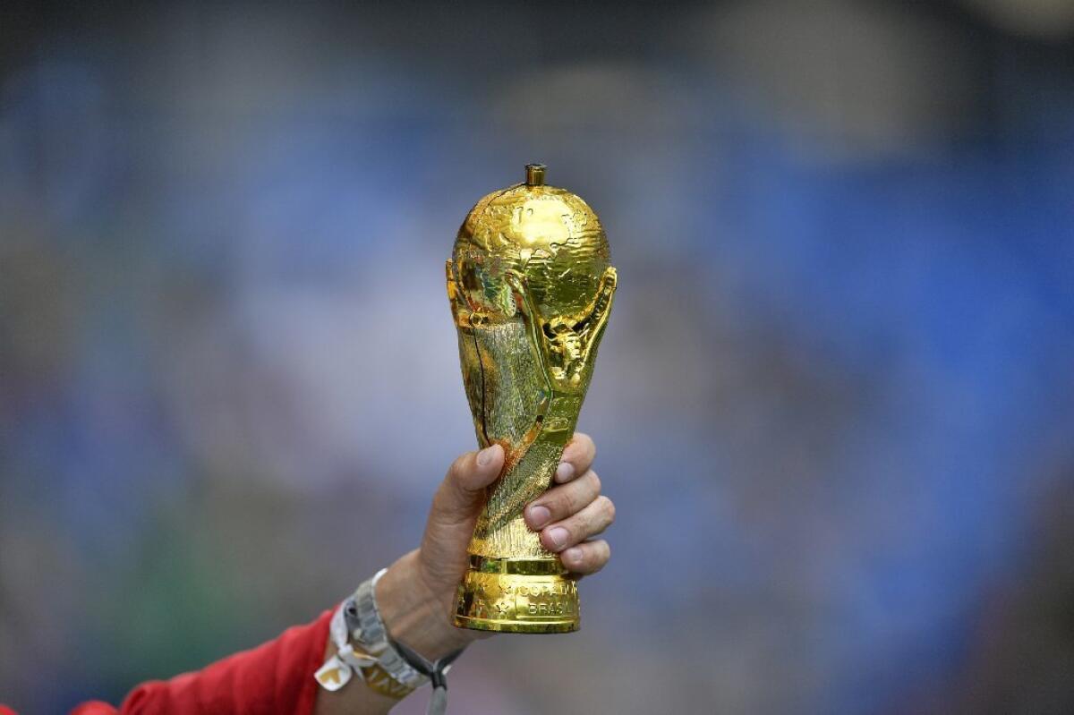 A fan holds a copy of the World Cup trophy prior to a match on Saturday.
