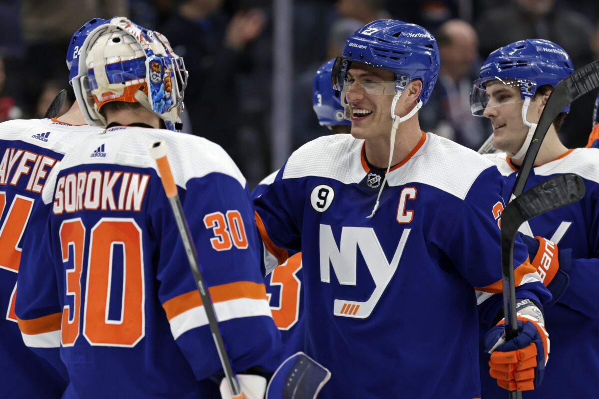 New York Islanders left wing Anders Lee celebrates with goaltender Ilya Sorokin after defeating the Columbus Blue Jackets in an NHL hockey game Thursday, March 10, 2022, in Elmont, N.Y. The Islanders won 6-0. (AP Photo/Adam Hunger)