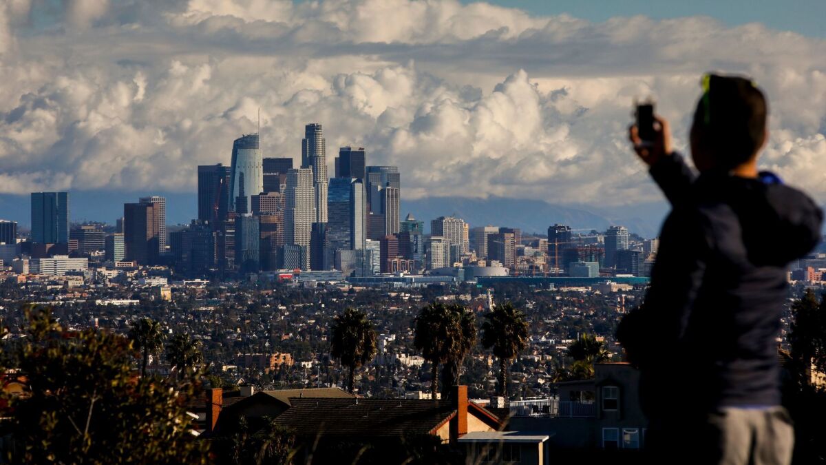 After dropping a friend at LAX airport, Mike Che, from West Hollywood, stopped at Kenneth Hahn State Recreation Area to take in the skyline of downtown Los Angeles, CA, following a winter storm, Christmas Eve morning.