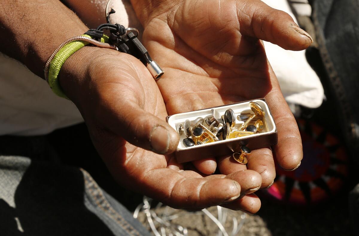 Jason Antoine Logan shows cuff links and simple jewelry he has found.