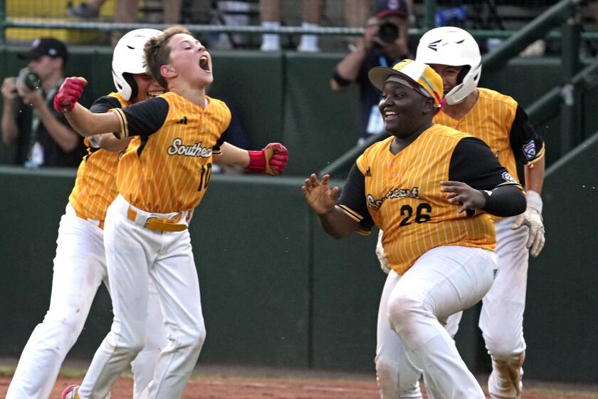 Lake Mary, Fla.'s Hunter Alexander, left, celebrates with teammates after laying down a walk-off bunt.