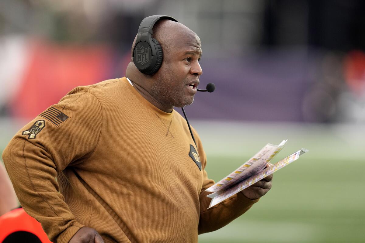 Former Washington Commanders offensive coordinator Eric Bieniemy stands on the sideline during a game.