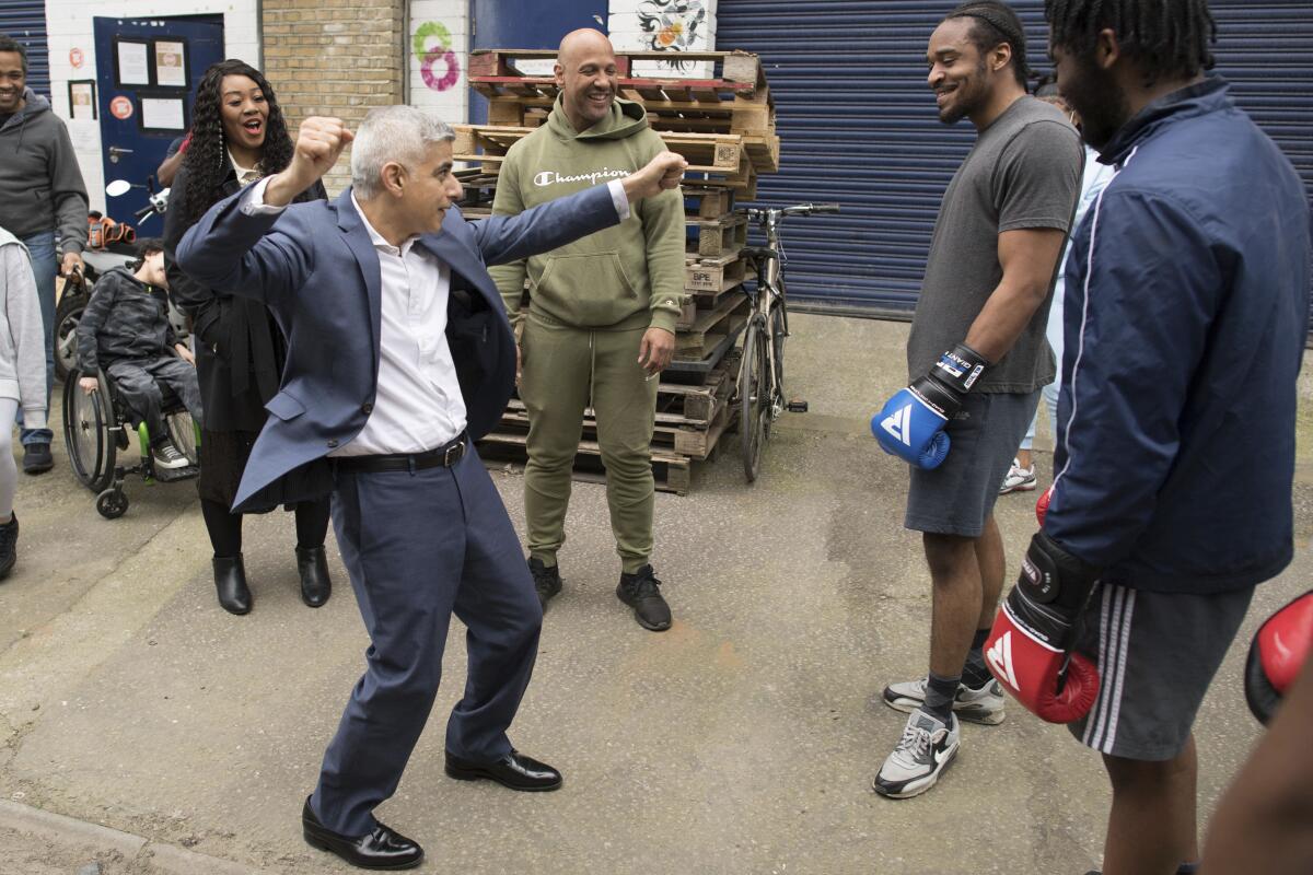 Labour's Mayor of London Sadiq Khan, foreground centre, gestures, during his visit to Dwaynamics Boxing Club while on the campaign trail for the London Mayoral election, in Brixton, south London, Thursday April 8, 2021. (Stefan Rousseau/PA via AP)
