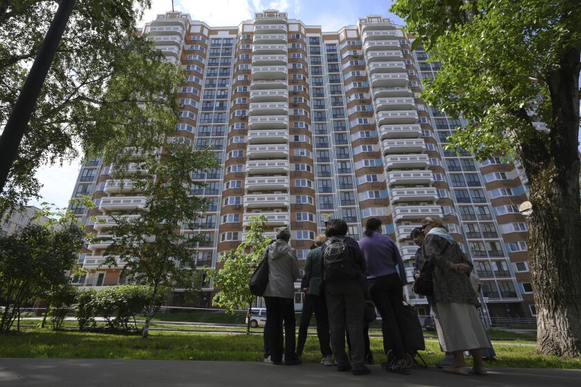 People look at a the apartment building in Moscow, Russia, damaged by a drone in an attack that authorities blamed on Ukraine, Tuesday, May 30, 2023. In Moscow, residents reported hearing explosions and Mayor Sergei Sobyanin later confirmed there had been a drone attack that he said caused "insignificant" damage. (AP Photo)