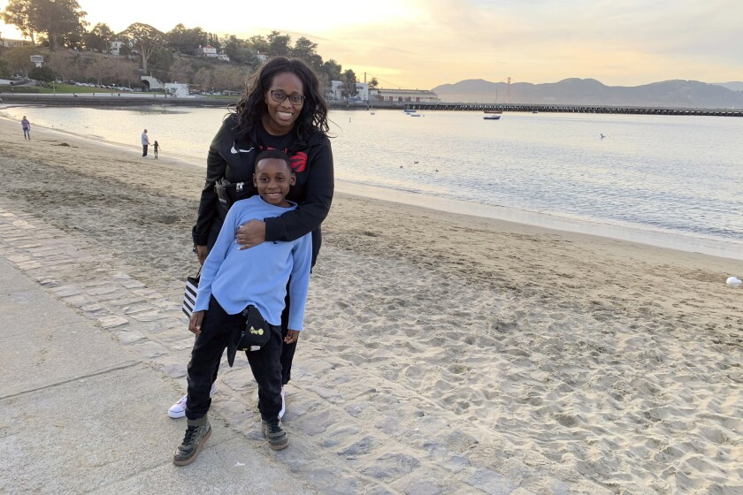 In this photo provided by Tanya Hayles, Hayles poses with her son Jackson, 7, in this undated photo. Hayles, founder of Black Moms Connection, an online network of more than 16,000 Black mothers with chapters across North America and Asia, said she has noticed discussions among members about how remote learning has allowed Black mothers to better shield their children from racism. (Courtesy of Tanya Hayles via AP)
