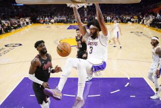 Los Angeles Lakers forward Anthony Davis, center, dunks as Portland Trail Blazers center Deandre Ayton defends during the second half of an NBA basketball game Sunday, Nov. 12, 2023, in Los Angeles. (AP Photo/Mark J. Terrill)