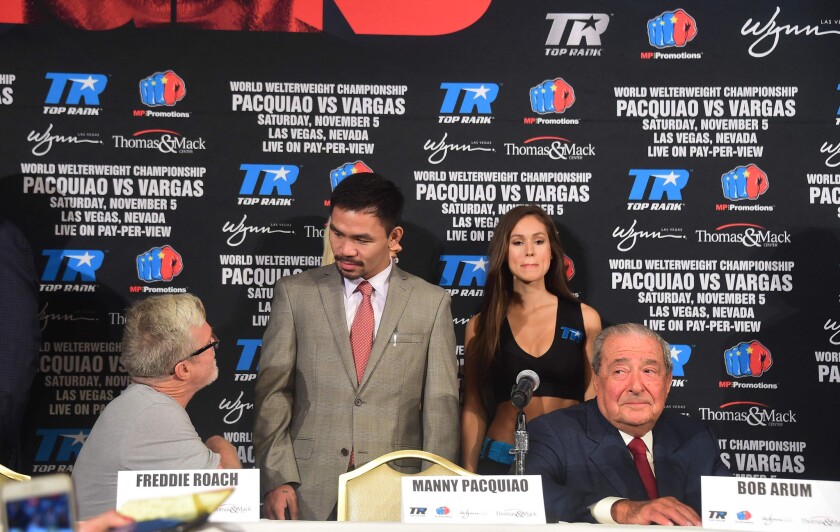 Manny Pacquiao, center, chats with trainer Freddie Roach at a news conference in Beverly Hills on Sept. 8. Promoter Bob Arum is at right.