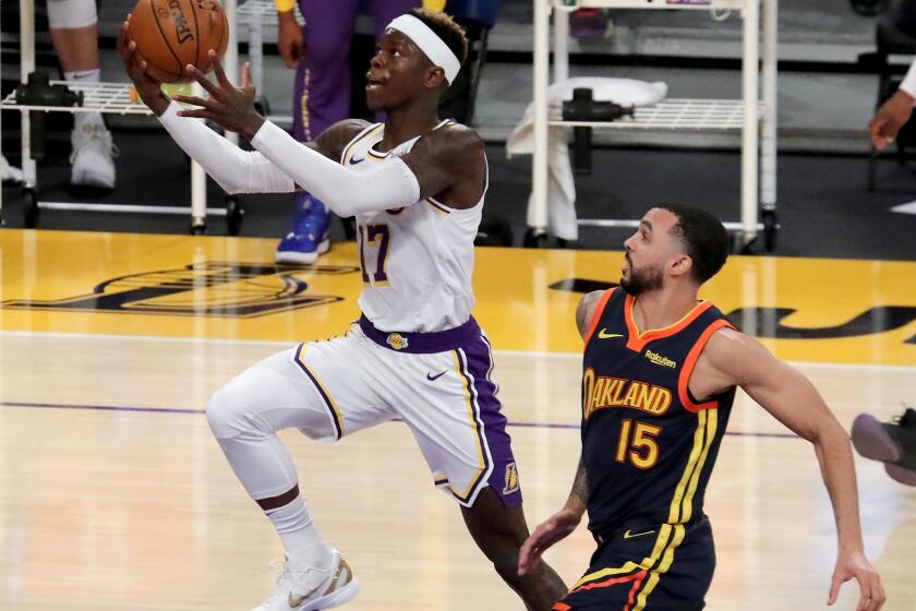 LOS ANGELES, CALIF. - FEB. 28, 2021. Lakers guard Dennis Schroder slices to the basket against Warriors guard Mychal Mulder in the first quarter of Sunday night's game, Feb. 28, 2020, at Staples Center in Los Angeles. (Luis Sinco/Los Angeles Times)
