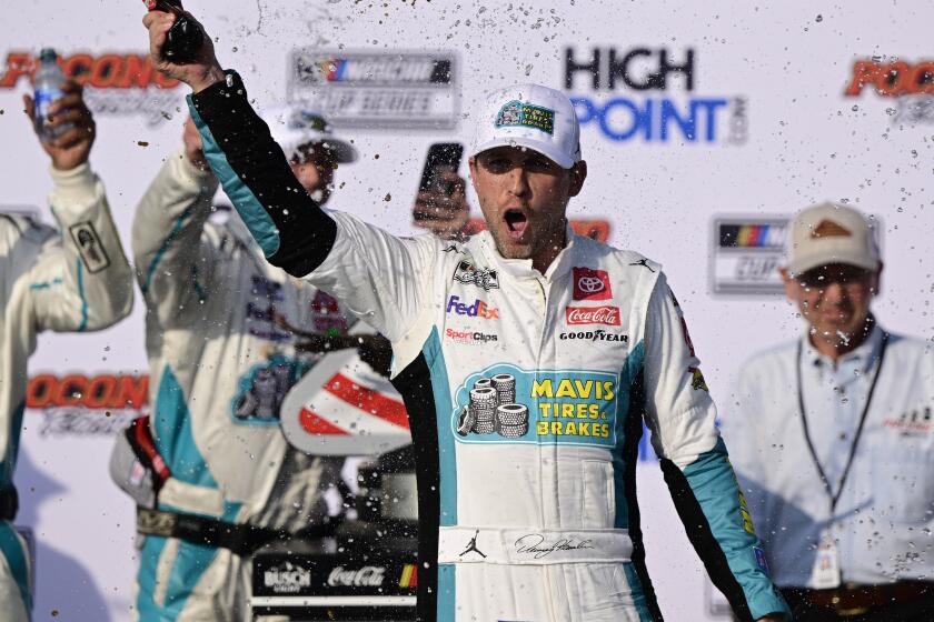 Denny Hamlin celebrates in Victory Lane after winning a NASCAR Cup Series auto race at Pocono Raceway.