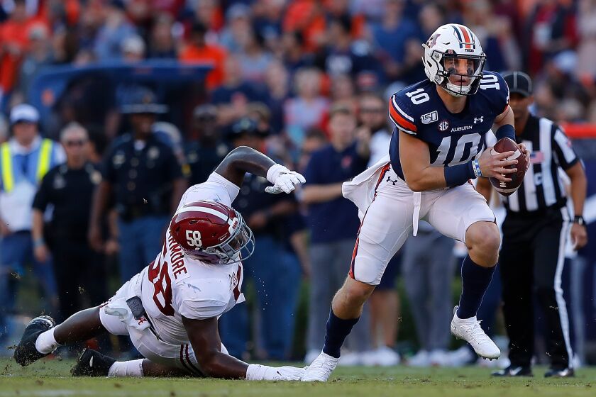 AUBURN, ALABAMA - NOVEMBER 30: Bo Nix #10 of the Auburn Tigers breaks a tackle by Christian Barmore #58 of the Alabama Crimson Tide in the first half at Jordan Hare Stadium on November 30, 2019 in Auburn, Alabama. (Photo by Kevin C. Cox/Getty Images) ** OUTS - ELSENT, FPG, CM - OUTS * NM, PH, VA if sourced by CT, LA or MoD **