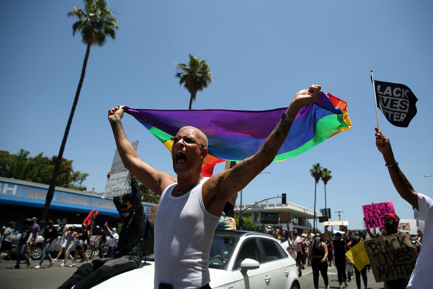 A protester waves a rainbow flag on Sunset Boulevard during All Black Lives Matter march