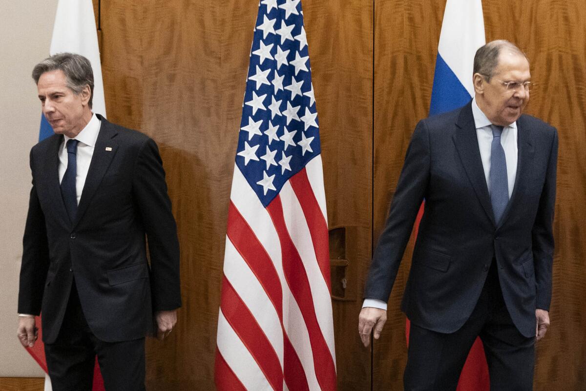 Antony Blinken and Sergei Lavrov move away from each other, toward their seats, before meeting in Geneva. 