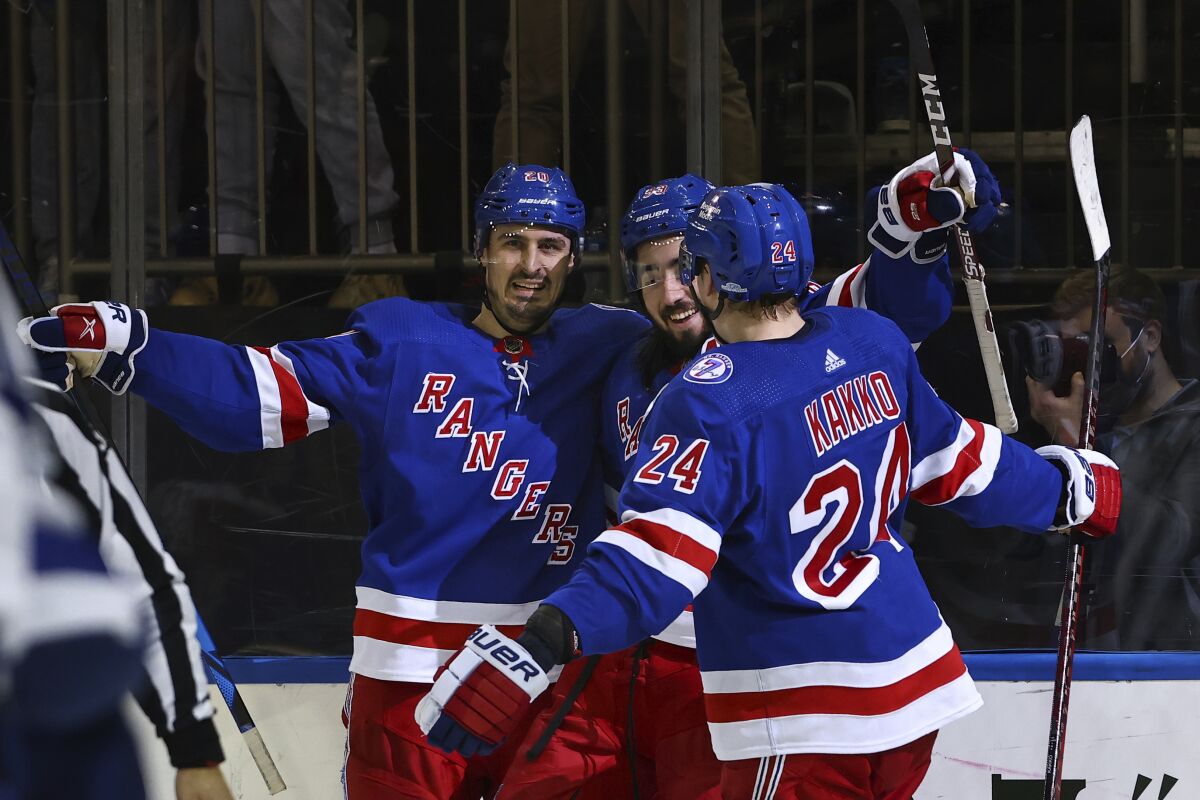 New York Rangers center Mika Zibanejad (93) is congratulated by teammates Chris Kreider (20) and Kaapo Kakko (24) after scoring his third goal against the Tampa Bay Lightning, during the second period of an NHL hockey game, Sunday, Jan 2, 2022, at Madison Square Garden in New York. (AP Photo/Rich Schultz)