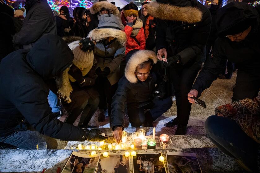 Mourners place candles and photographs outside the Alberta Legislature Building in Edmonton, Alberta, Wednesday, Jan. 8, 2020, during a vigil for those killed after a Ukrainian passenger jet crashed, killing at least 63 Canadians, just minutes after taking off from Iran's capital. (Codie McLachlan/The Canadian Press via AP)