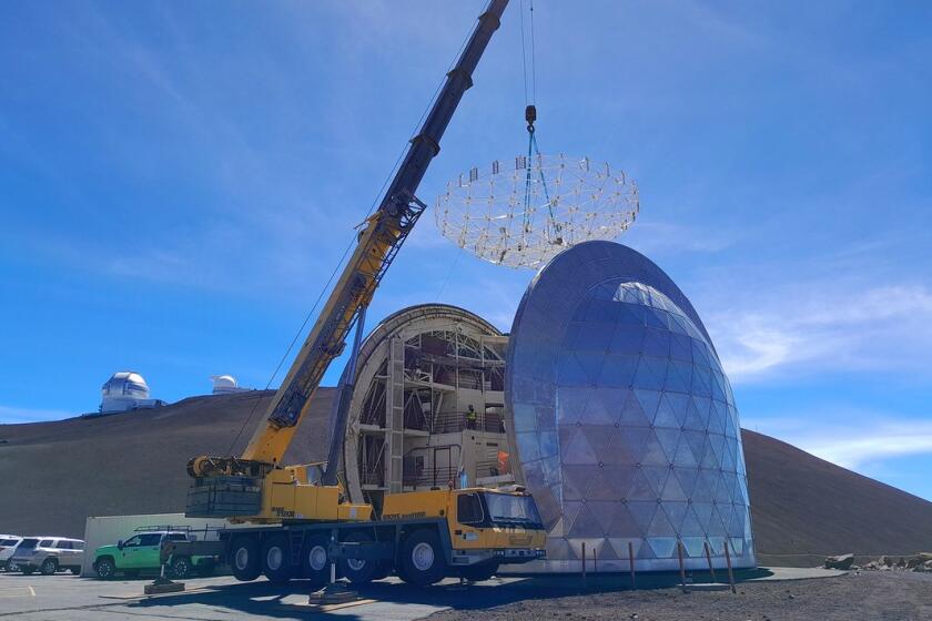 A crane removing the primary mirror truss off of the Caltech Submillimeter Telescope's base