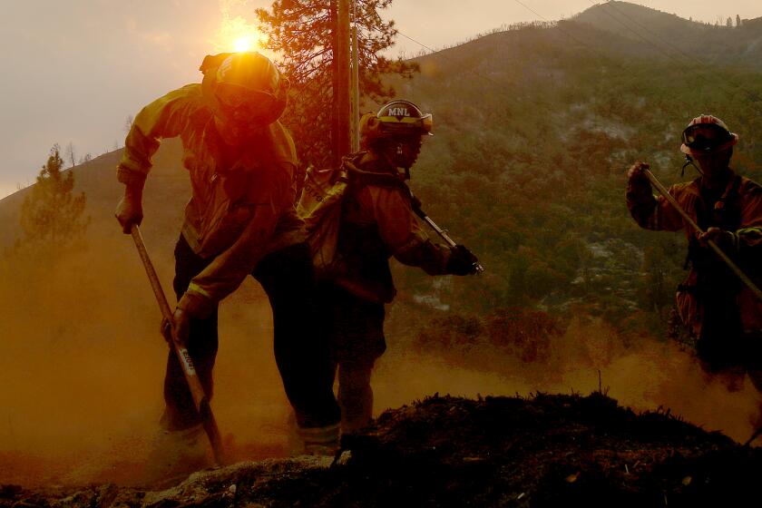 MARIPOSA, CALIF. - JULY 26, 2022. Firefighters put out hotspots from the Oak fire along Darrah Road near Mariposa on Tuesday, July 26, 2022. (Luis Sinco / Los Angeles Times)