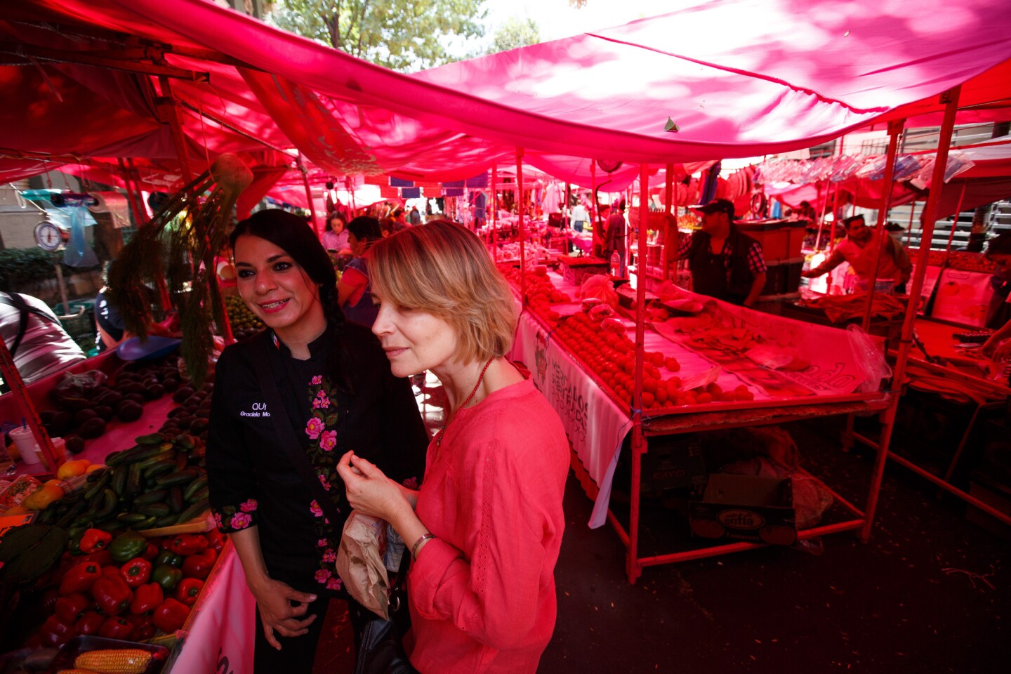 One way to explore a city is through its food. In Mexico City, Graciela Montaño, left, leads Liz Elliot on a tour of a traditional open-air market as part of an Aura Club de Maridaje tour.