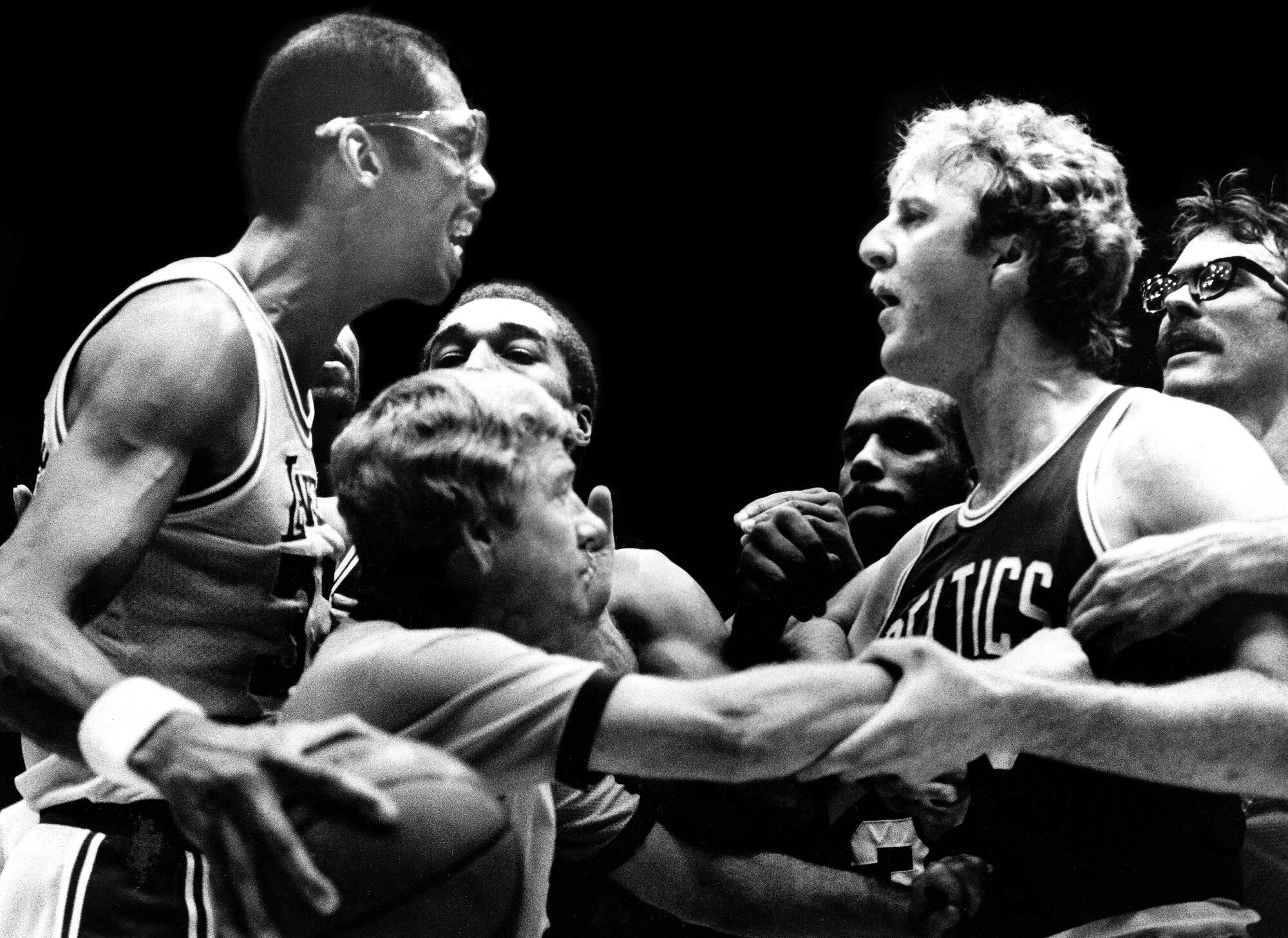 Men pull Kareem Abdul-Jabbar and Larry Bird away from each other