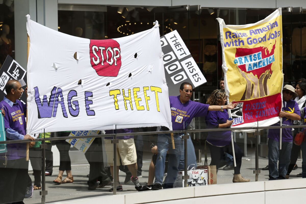 Workers in May hold a rally at the Figat7th shopping center in downtown Los Angeles, supporting anti-wage-theft legislation and a $15-an-hour minimum wage.
