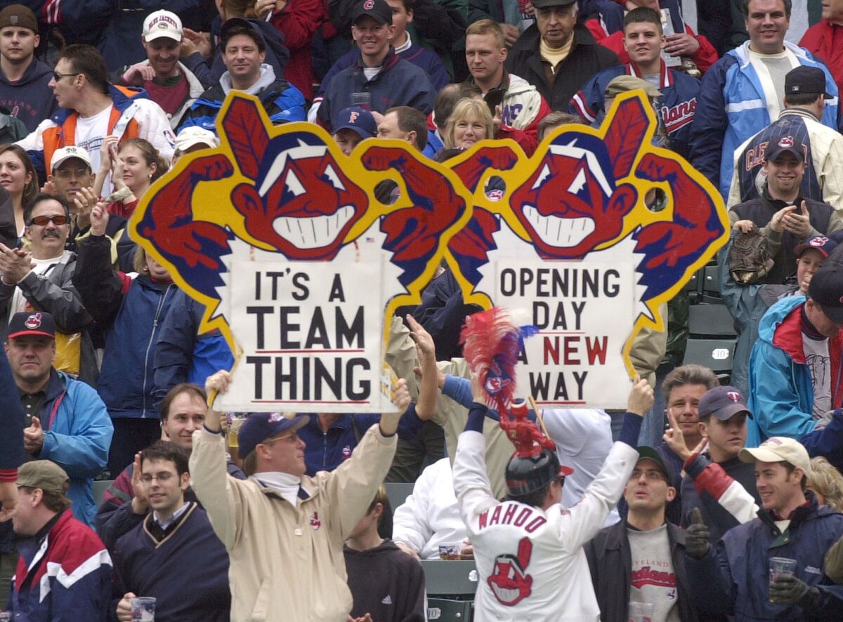 Cleveland Indians fans hold up Chief Wahoo logo signs in 2002.