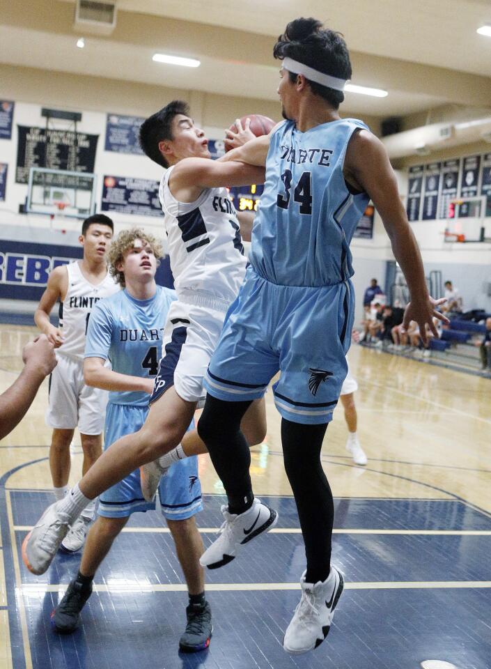 As Flintridge Prep's Zach Kim jumps into the paint, he is fouled while shooting by Duarte's Joshua Crespo in a non-league boys' basketball game at Flintridge Prep on Monday, December 3, 2018.