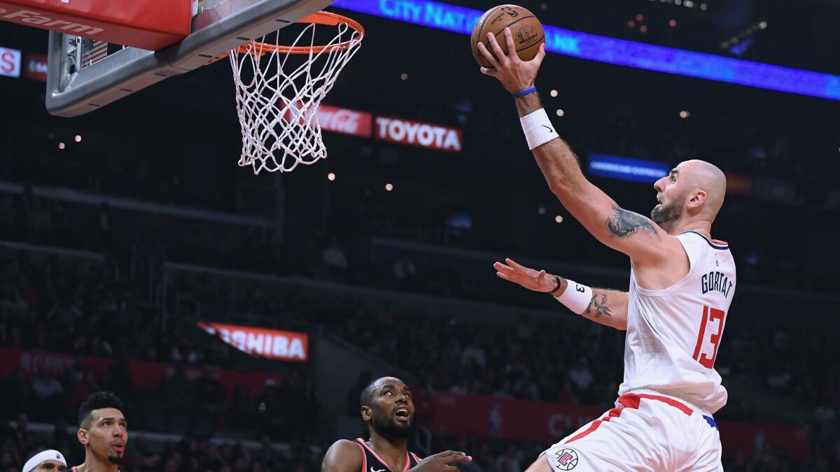 Marcin Gortat of the Clippers drives to the basket near Serge Ibaka of the Toronto Raptors during Tuesday's game at Staples Center.